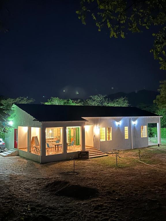 uma pequena casa iluminada à noite com luzes em Verde del Limonar Casa de Campo em Girardot