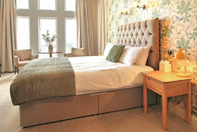 um quarto com uma cama grande e uma mesa em The Marine Hotel em Hartlepool