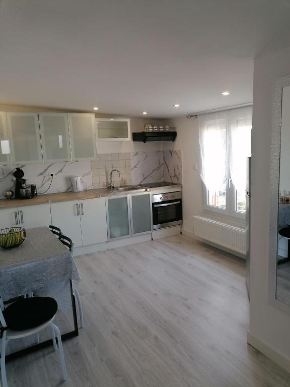 cocina con armarios blancos y suelo de madera en Appartement moderne en Rouvroy