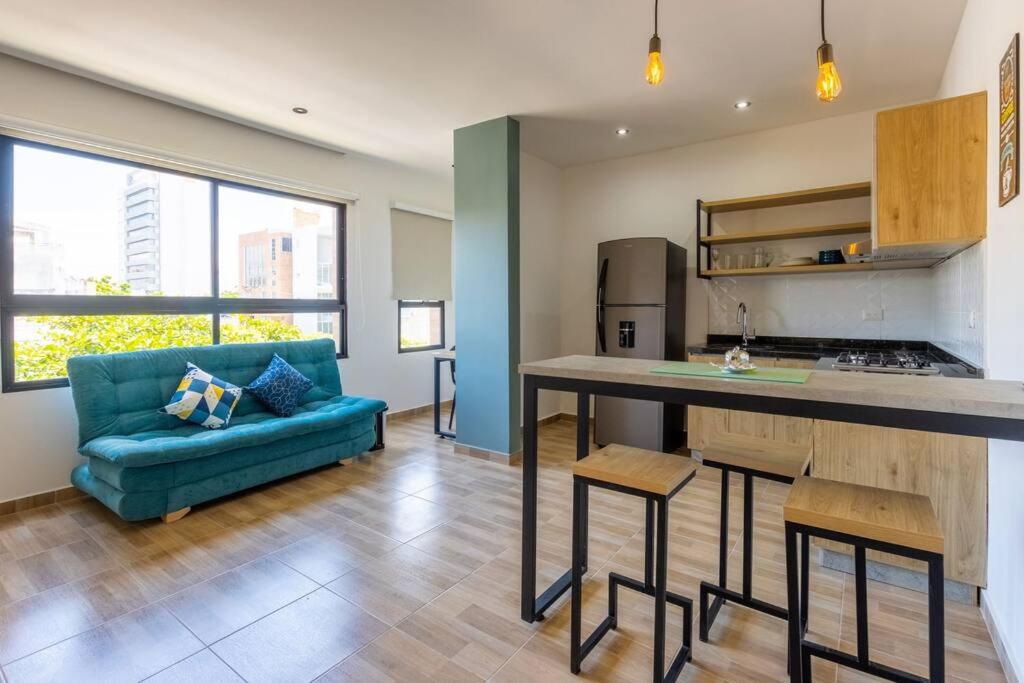 a kitchen and living room with a blue couch at EXCLUSIVO LOFT. CAOBOS COLIVING&COWORKING. ZONA T in Cúcuta
