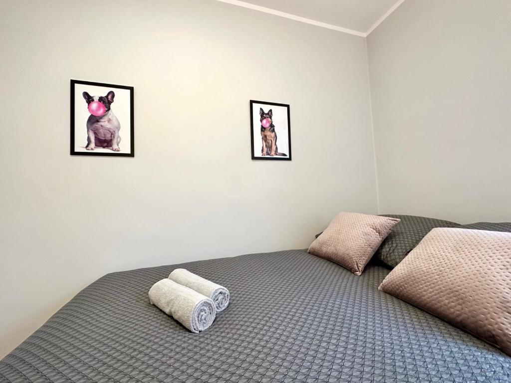 a bedroom with a bed with two pictures on the wall at MMRent Bubble Gum Room in Gdańsk