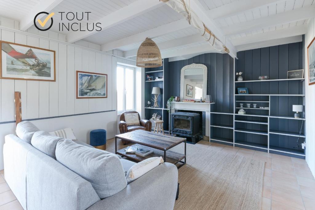 ein Wohnzimmer mit einem Sofa und einem Tisch in der Unterkunft TY STREJOU - Jolie maison de pêcheur proche port in Ploudalmézeau