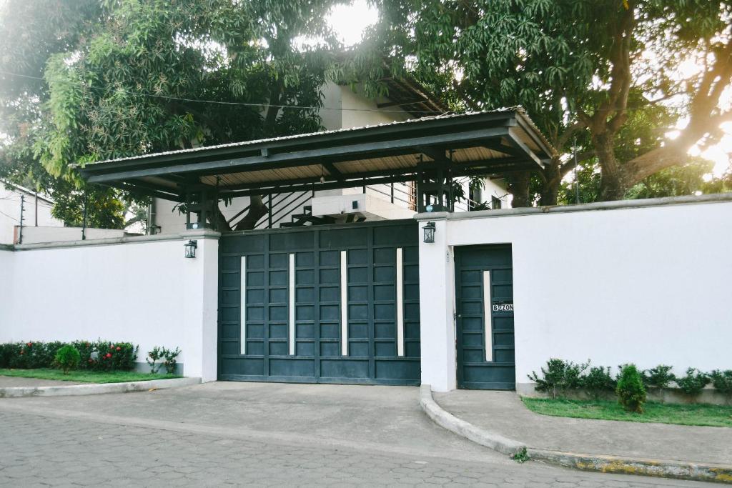 een wit gebouw met een groene garagedeur bij La casa Blanca Ticuantepe in Ticuantepe