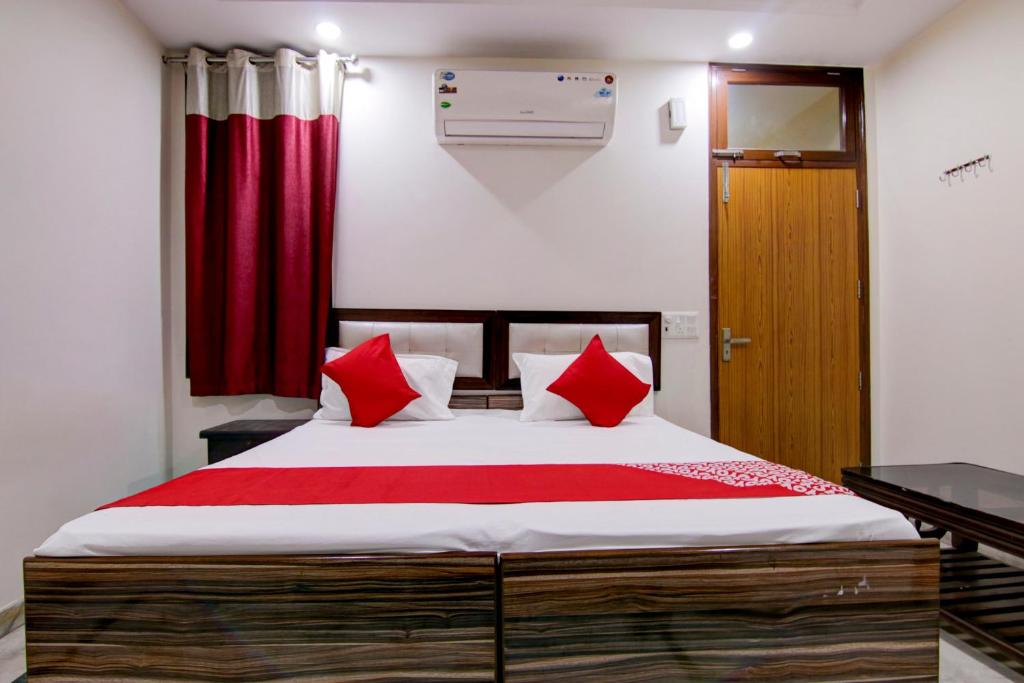 a bedroom with a large bed with red pillows at Flagship Shyam Villa in New Delhi