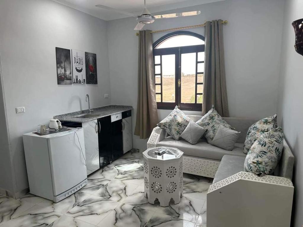 a living room with a couch and a kitchen at Elwazan Hotel in Quseir