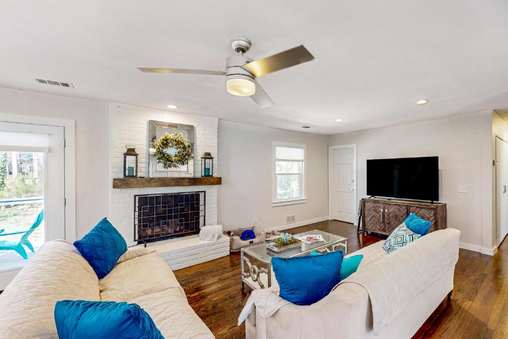 a living room with white furniture and a fireplace at Happy Camper Haven in Alpharetta