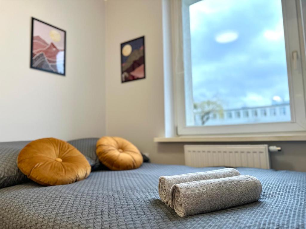 a bed with two ottomans with towels on it at MMRent Moonlight Room in Gdańsk