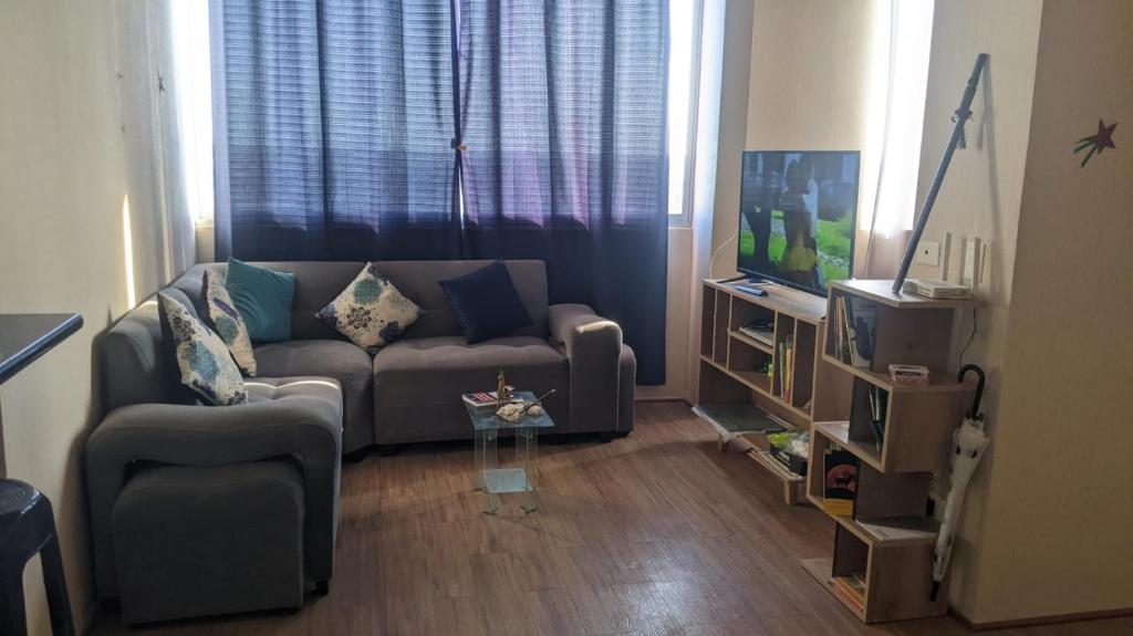 a living room with a couch and a tv at Apartamento en Piura - Perú in Piura