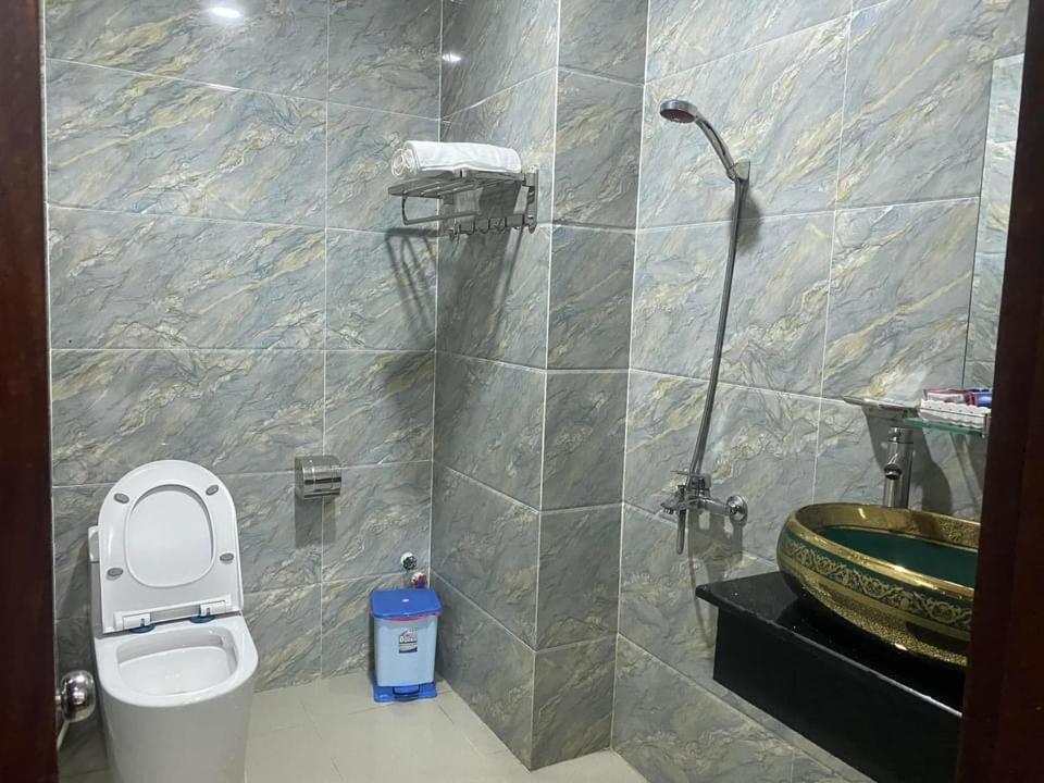 e bagno con doccia, servizi igienici e lavandino. di Khách sạn MINH NHẬT ad Ho Chi Minh