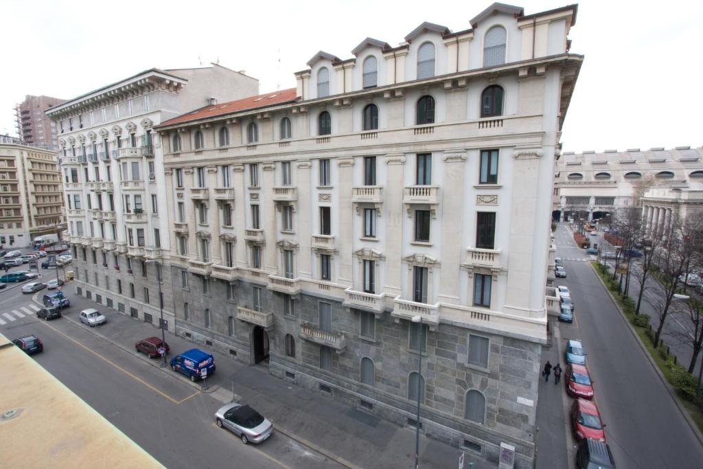 - un grand bâtiment blanc dans une rue de la ville dans l'établissement Residence De La Gare, à Milan