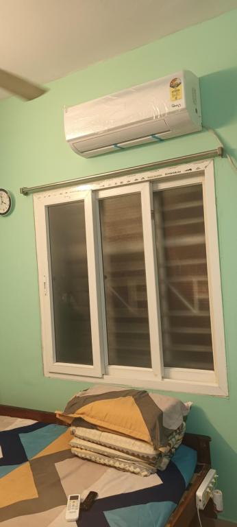 ventana en una habitación con ventilador y almohada en LENKA BHAWAN, en Bhubaneshwar