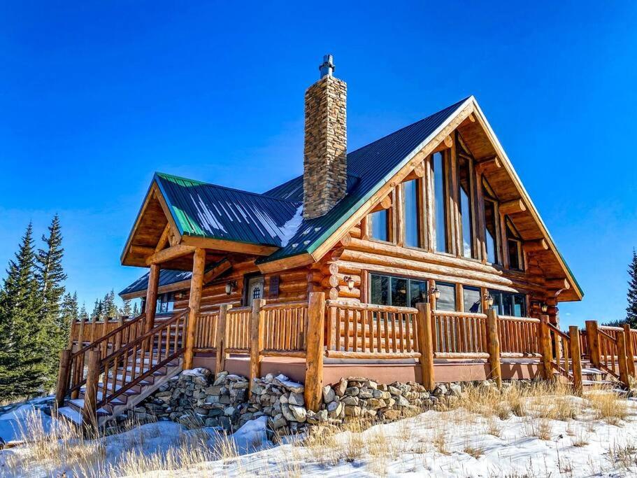 una cabaña de madera en invierno con nieve en Spectacular Custom Log Cabin with Hot Tub, Epic Views, Fireplace - Moose Tracks Cabin, en Fairplay