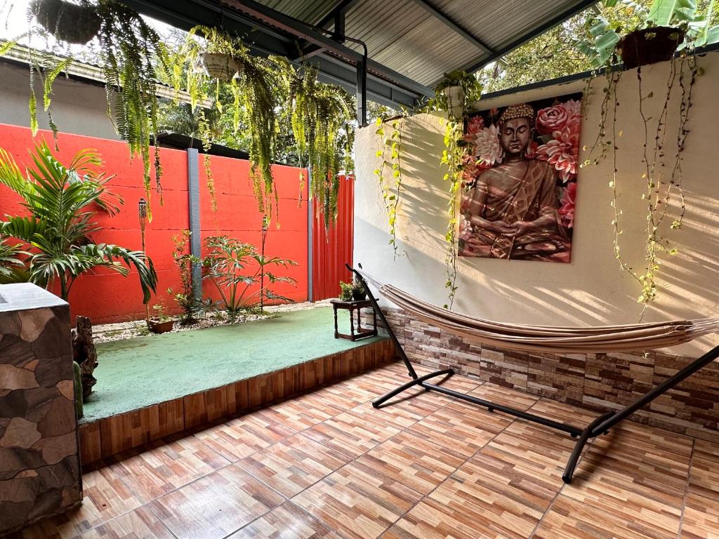 a hammock on a patio with a picture of a buddha at Retiro Arenal in Fortuna