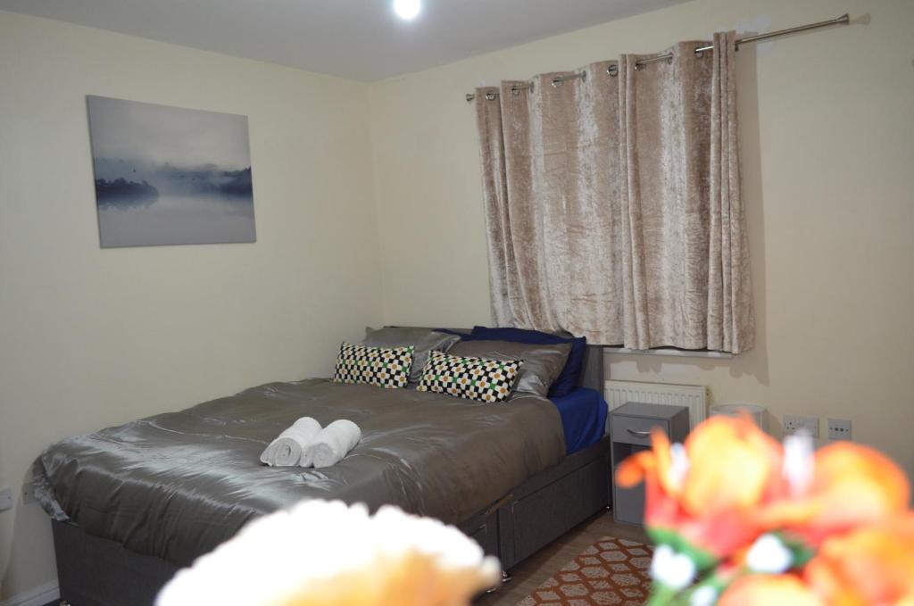een slaapkamer met een bed en 2 witte handdoeken bij Nice and Cosy Flat in London/Ilford/Barking, United Kingdom in Barking