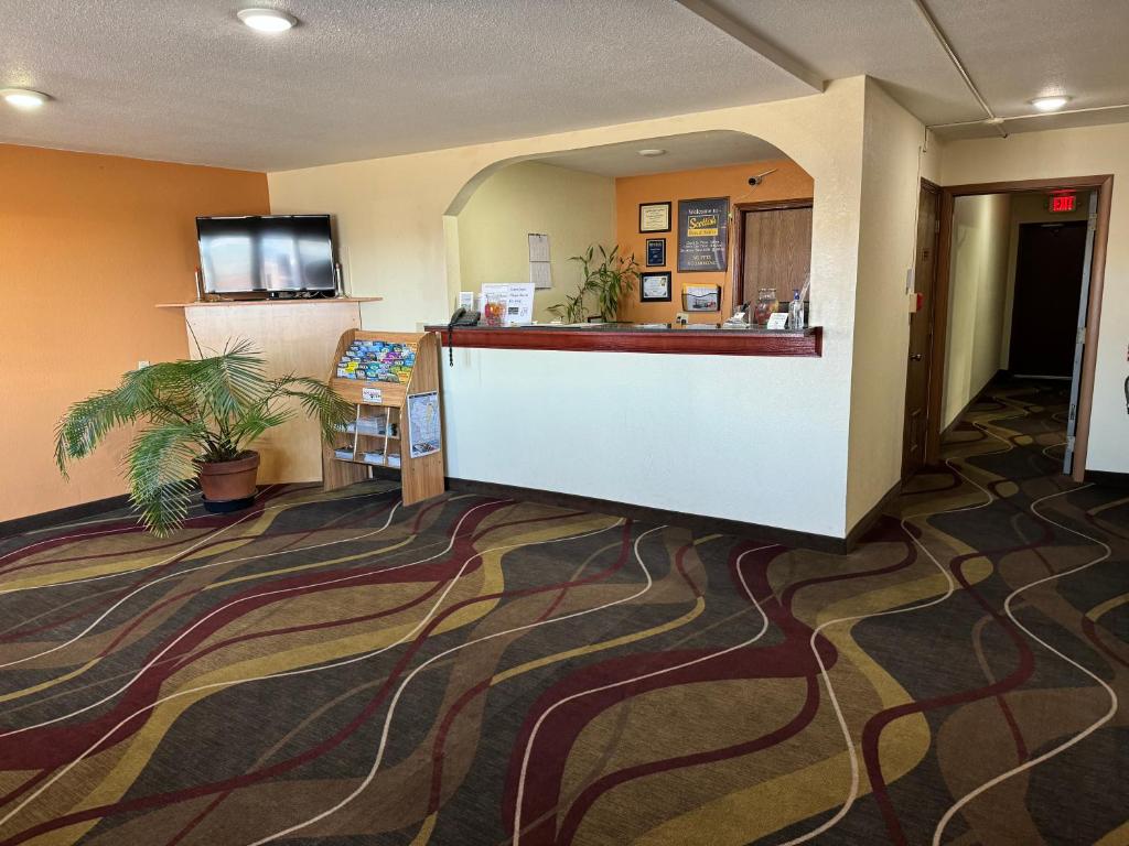 a hotel room with a lobby with a reception counter at Scottish Inn & Suites - Eau Claire in Eau Claire