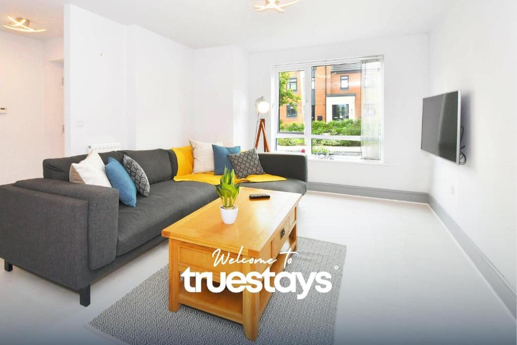 a living room with a couch and a table at Kiln Side by Truestays - 3 Bedroom House in Etruria