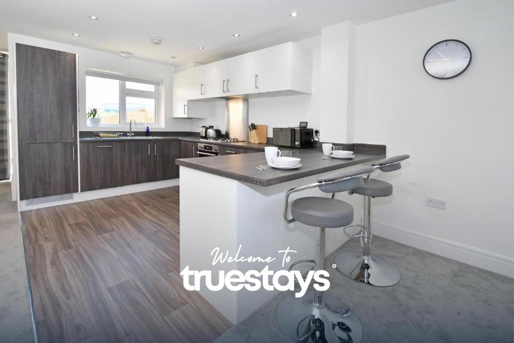 a kitchen with white cabinets and a counter top at Regal House by True Stays - 3 Bedroom House in Stoke-on-Trent in Stoke on Trent