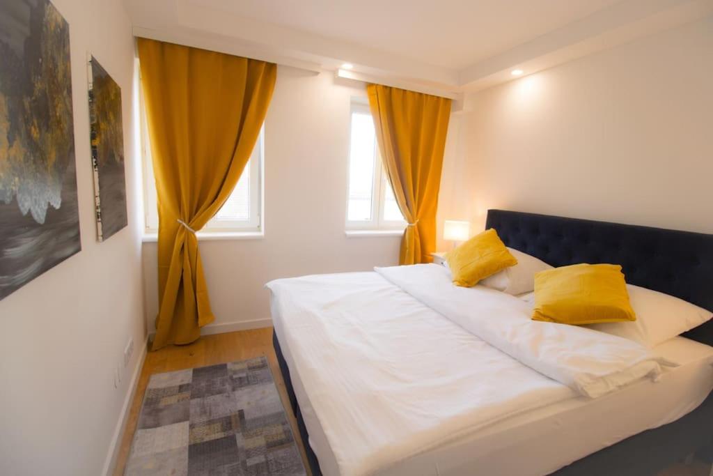 ein weißes Bett mit gelben Kissen im Schlafzimmer in der Unterkunft Charming Apartment in Heart of Vienna JOS 20 in Wien