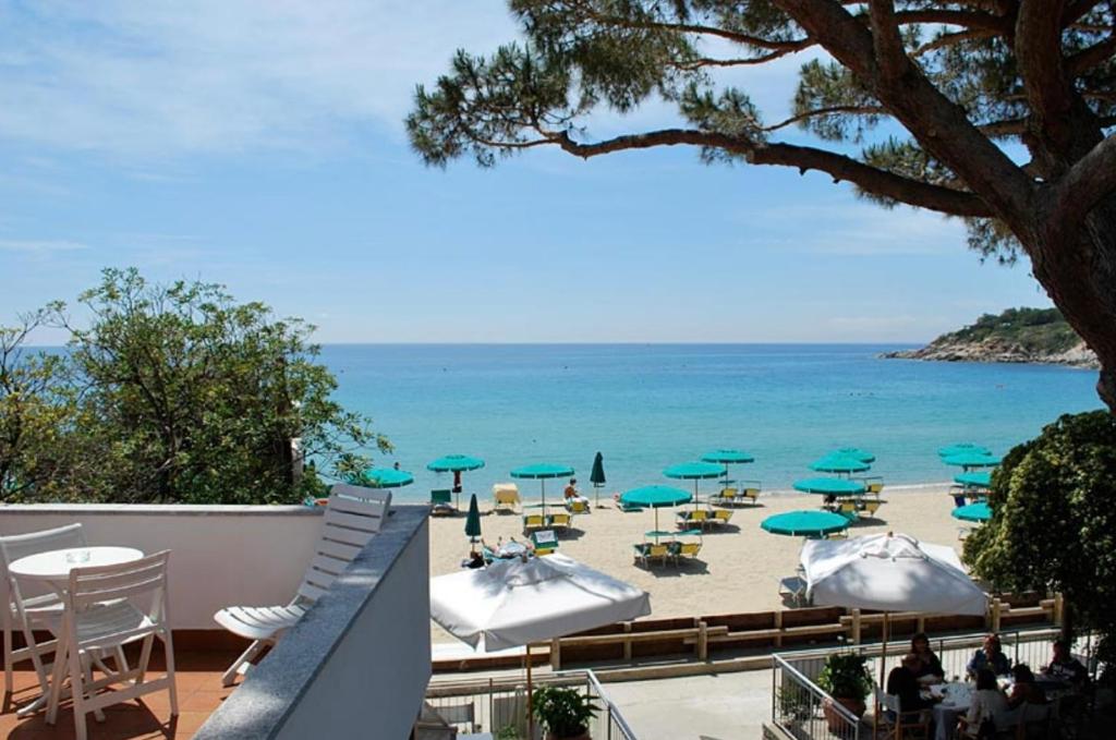 a view of a beach with umbrellas and chairs at Hotel Lorenza B&B e Mini Suite in Cavoli