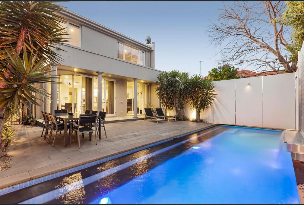 a house with a swimming pool in front of a house at Luxurious Townhouse Retreat in Prestigious Brighton in Melbourne