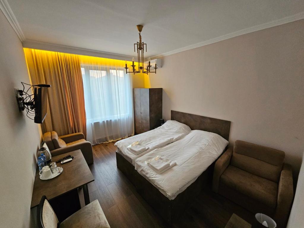 um quarto de hotel com uma cama e uma cadeira em Bina N28 em Kutaisi