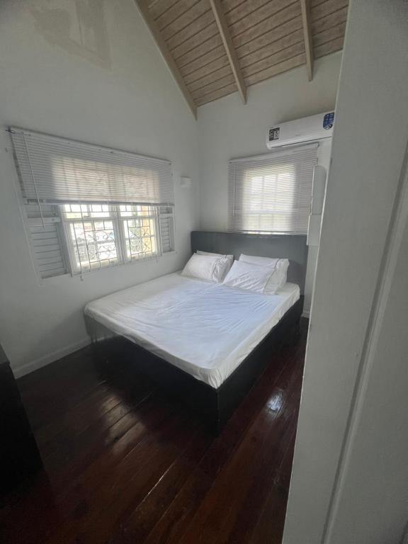 Cama en habitación blanca con 2 ventanas en holiday home 2 bed, en DʼArbeau