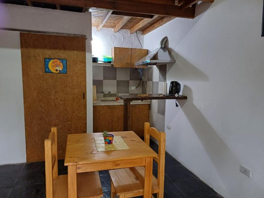 einen Holztisch und Stühle in einer kleinen Küche in der Unterkunft Departamento Juana Azurduy in Merlo
