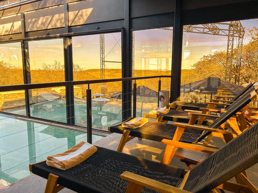 - une vue sur un bâtiment avec des chaises et une piscine dans l'établissement La Forêt Cabañas Boutique, à León