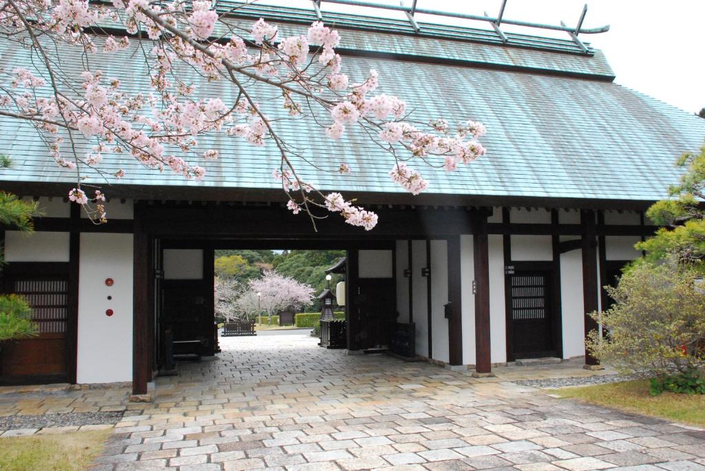 an entrance to a building with pink cherry blossoms at Yamaha Resort Katsuragi Kitanomaru in Fukuroi