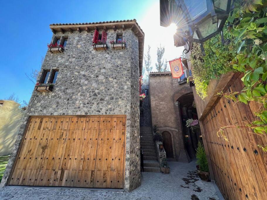 a building with a wooden gate with two chairs on it at Diego Loft en Val'Quirico Centro in Santeagueda