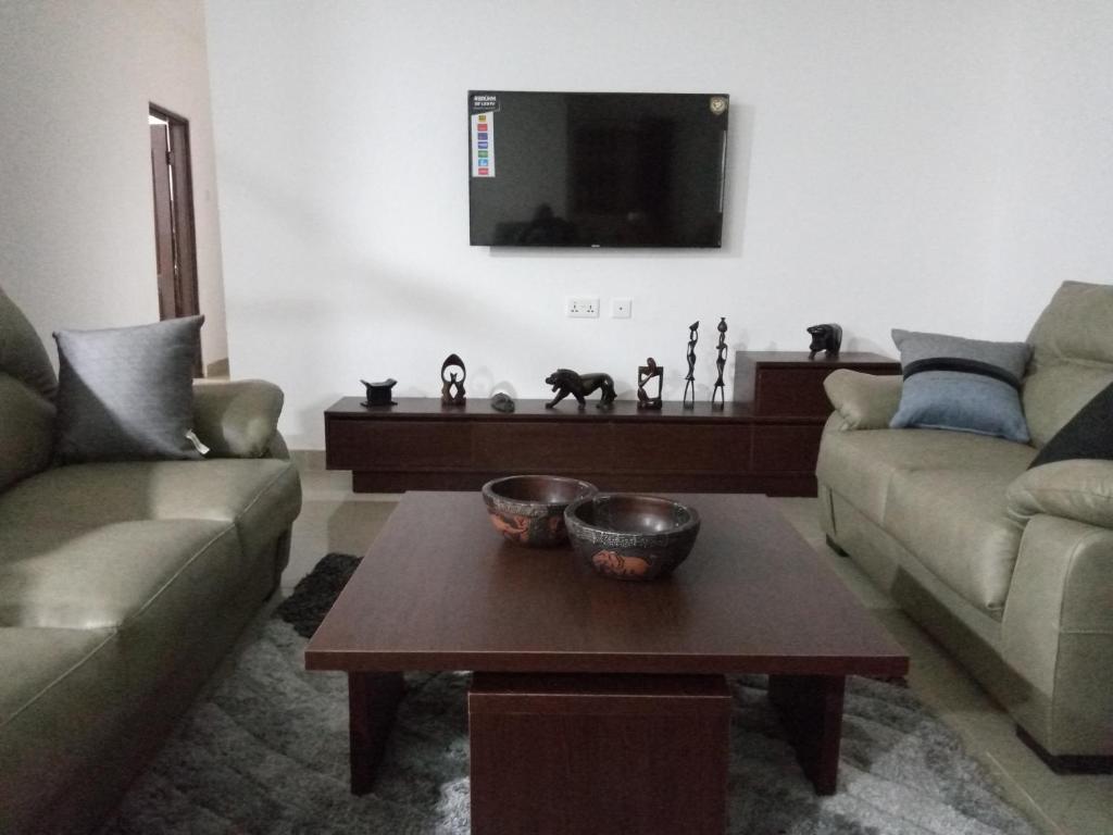 a living room with a couch and a coffee table at 3 Scone Villa in Apenkwa
