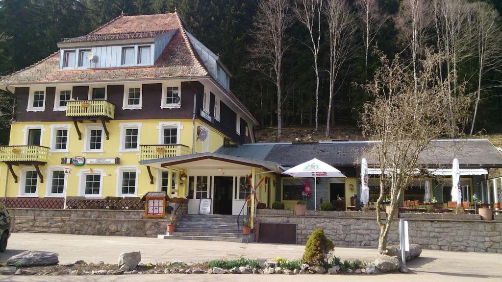 ein großes gelbes Haus mit einer Veranda in der Unterkunft Gasthaus Hotel Löffelschmiede in Hinterzarten