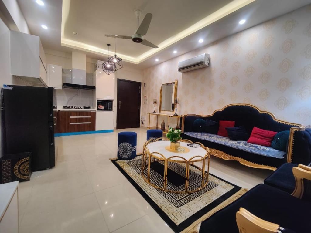 a living room with a blue couch and a table at 1 bed apartment infront of Centaurus in Islamabad