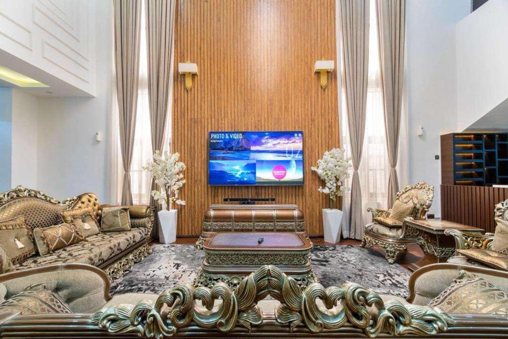 ein Wohnzimmer mit einem Sofa und einem Flachbild-TV in der Unterkunft Luxurious Six Bedroom Apartment in Lekki