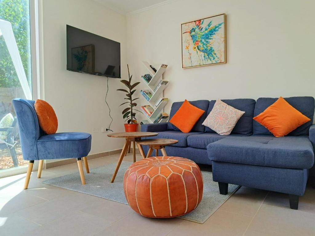 - un salon avec un canapé bleu et des oreillers orange dans l'établissement Hogar Entre Viñas, à Casablanca