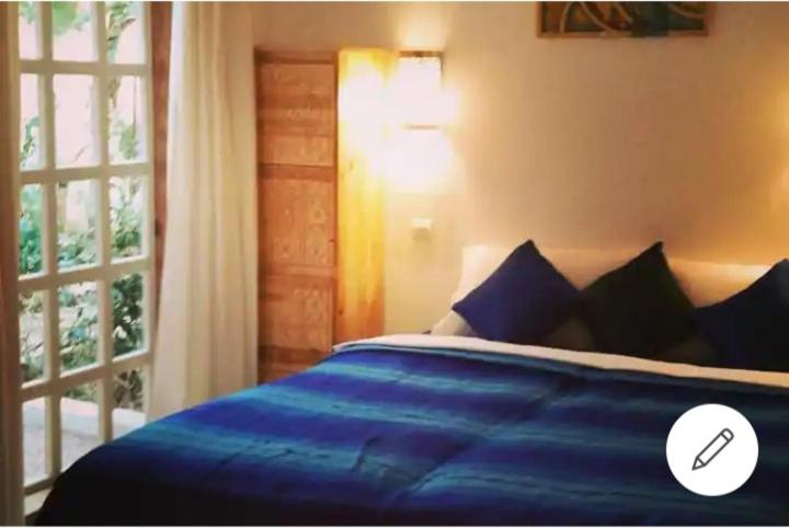 a bedroom with a blue bed and a window at Paradise Guest House in Agadir