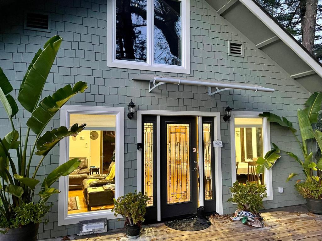 una casa con una puerta negra y un sofá en Avenue of the Giants River View Home (#1), 