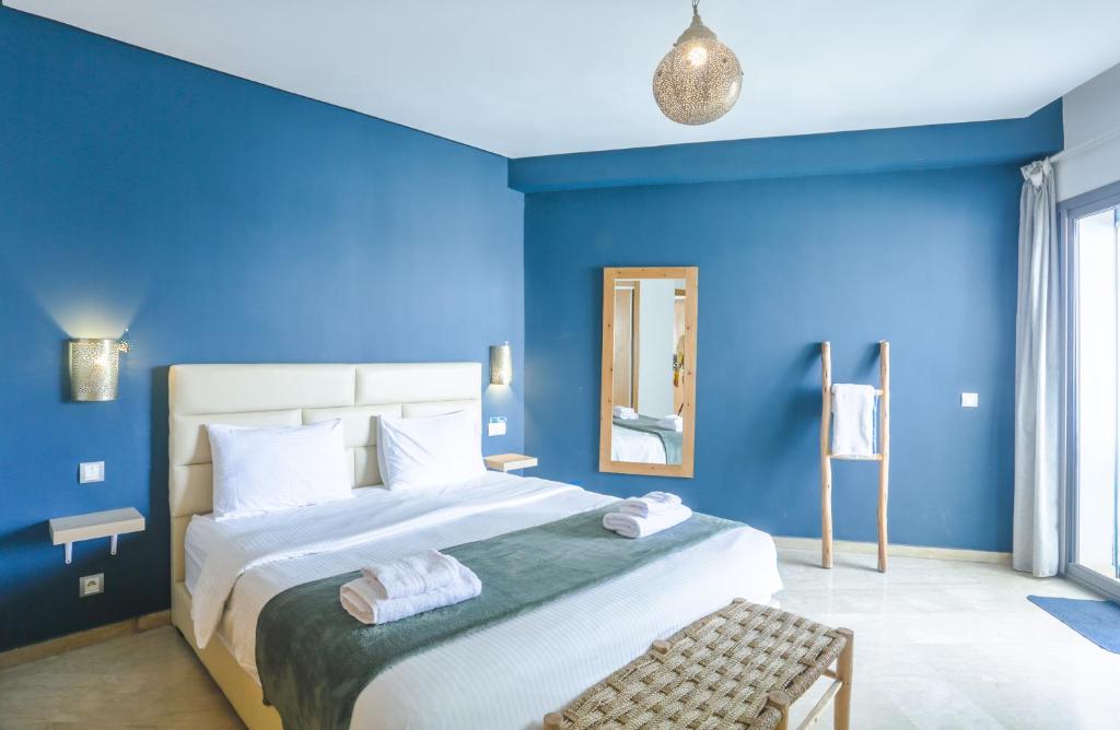 a blue bedroom with a large bed and a mirror at Résidence Liberté in Casablanca