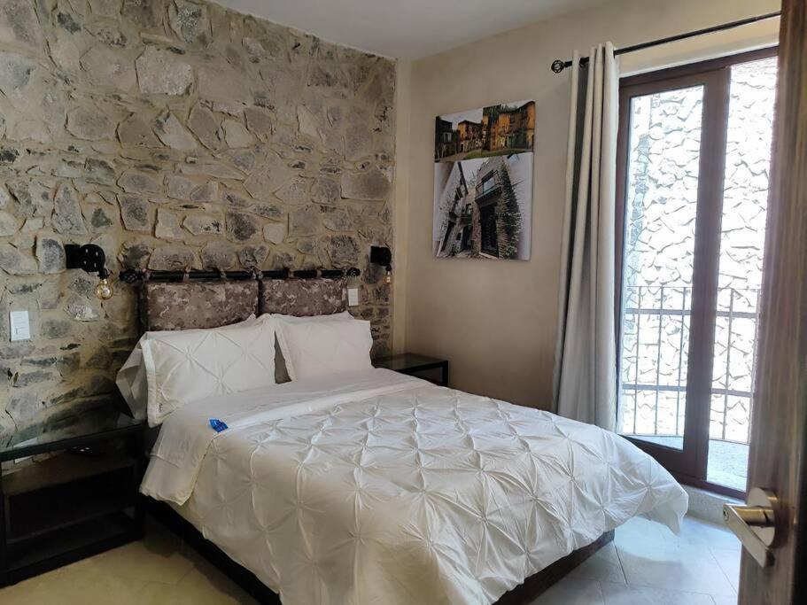 una camera da letto con un muro in pietra e un letto di Loft AMORE en Val'Quirico a Santeagueda