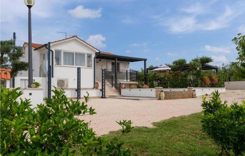 een wit huis met een oprit ervoor bij Family friendly house with a swimming pool Visnjan, Central Istria - Sredisnja Istra - 22837 in Višnjan