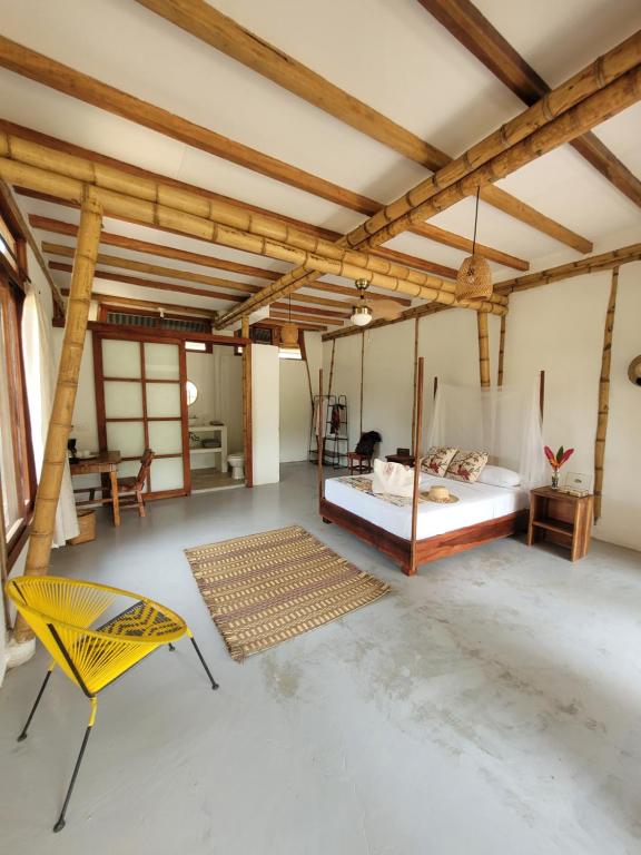 a bedroom with a bed and a chair in a room at Atalaya del Mar Palomino in Palomino