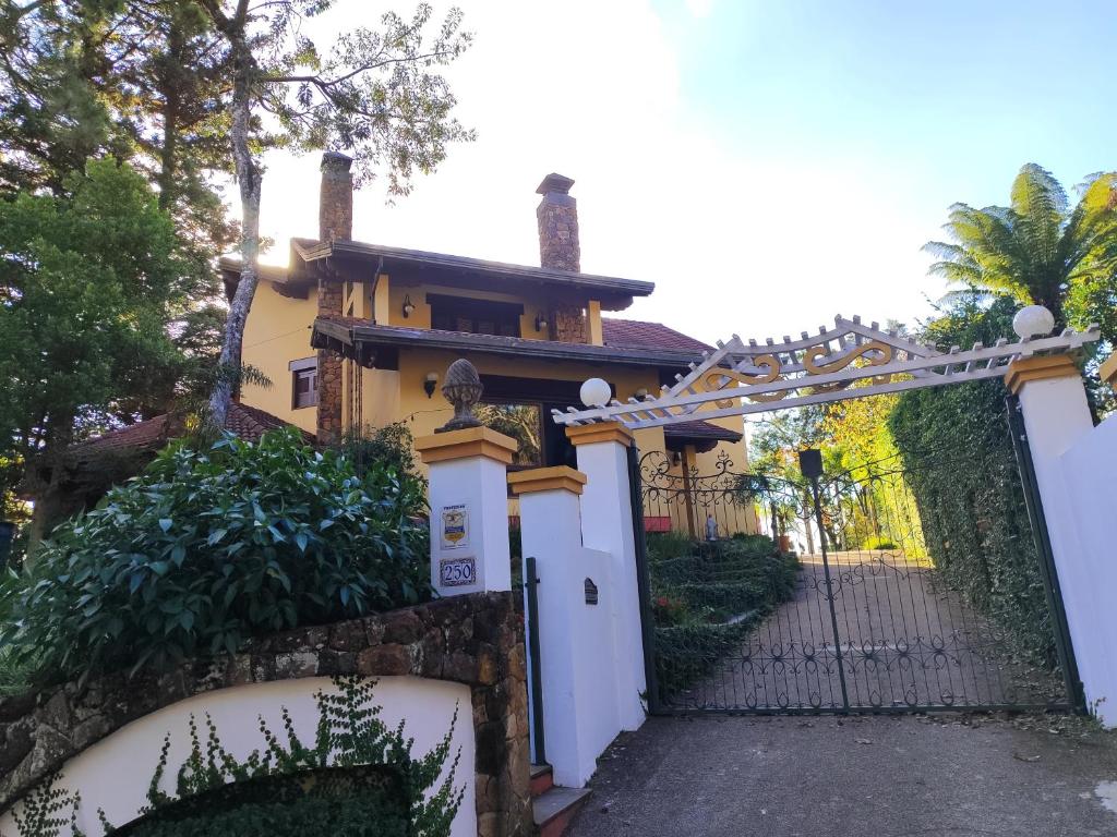 um portão para uma casa com uma cerca em Pousada Oscar Magic Gramado em Gramado
