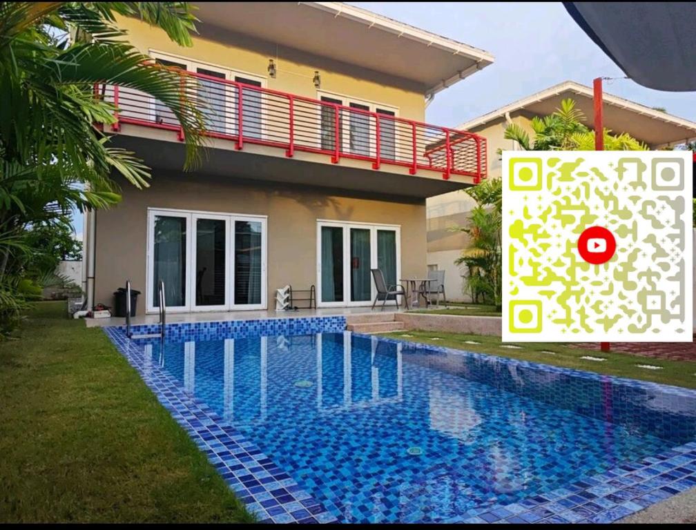 a villa with a swimming pool in front of a house at M-Residence in Pantai Cenang