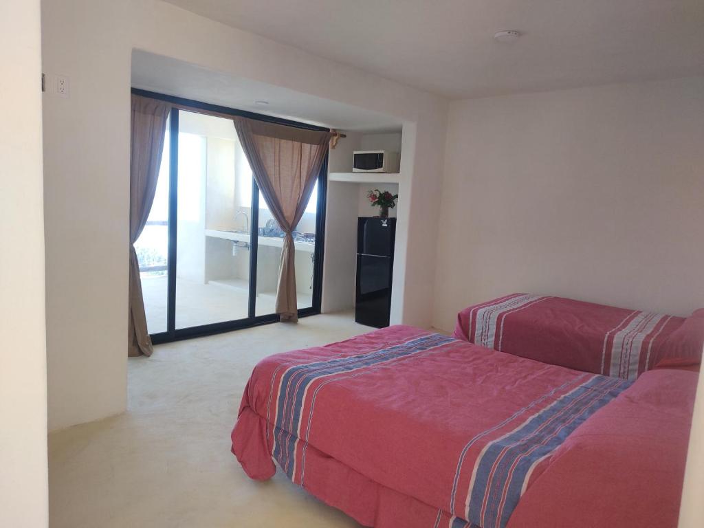 a bedroom with two beds and a large window at Villas Roberto's Bistro Mirador in Troncones