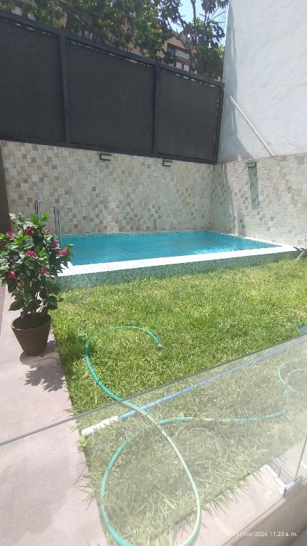 a swimming pool with a hose on the grass at Dna 44 in Lima