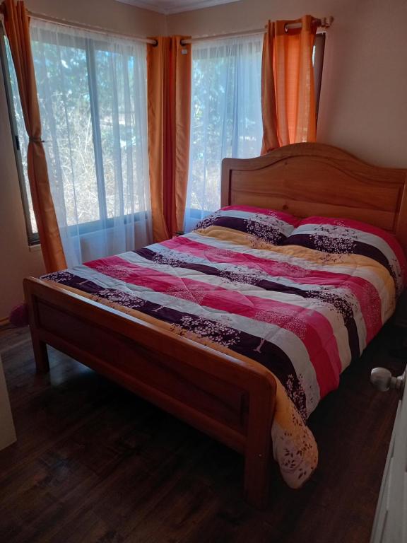 1 cama en una habitación con ventana en Cabaña Encantos del Mar, en Cáhuil