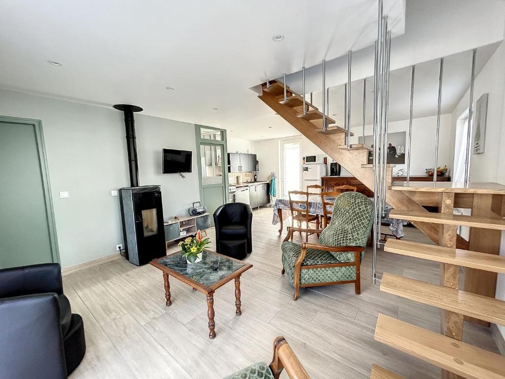 ein Wohnzimmer mit einer Treppe und einem Tisch in der Unterkunft Maison Jullouville, 3 pièces, 6 personnes - FR-1-361-464 in Jullouville-les-Pins