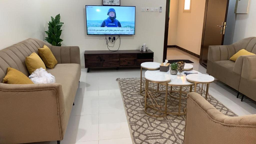 sala de estar con 2 sofás y TV en شقه مفروشة فاخره بدخول ذاتي, en Al Kharj