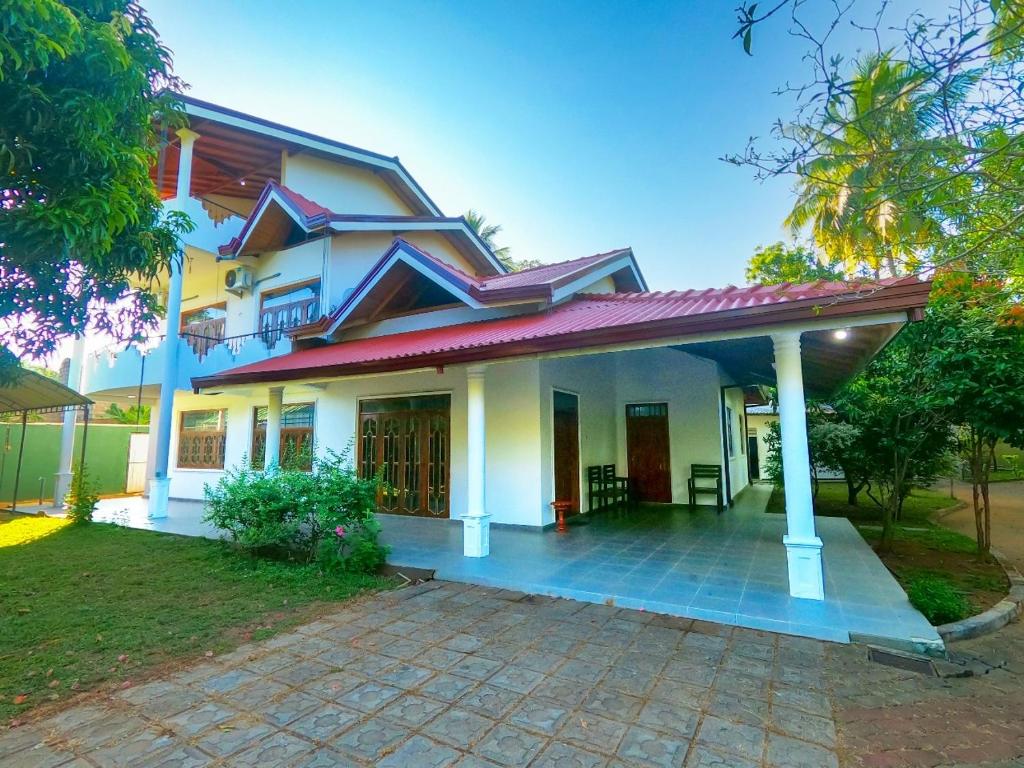 ein Haus mit einer Veranda und einer Auffahrt in der Unterkunft Elegant Riverside Villa in Dematapelessa