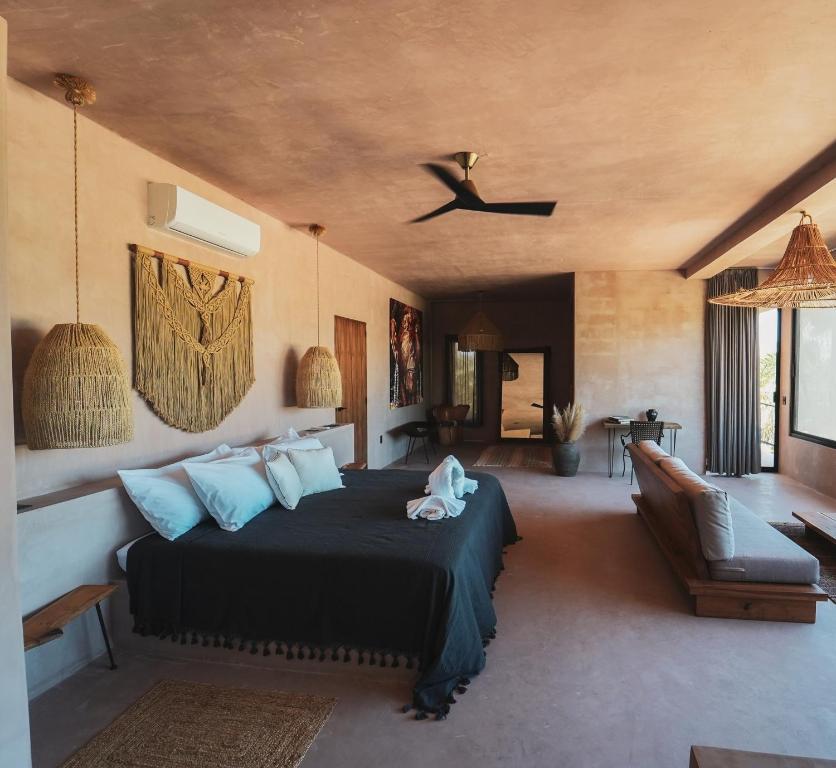 - une chambre avec un lit et un canapé dans l'établissement Nikau Hotel El Cuyo - Adults Only, à El Cuyo